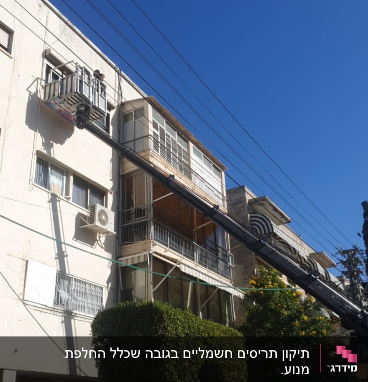 תריסים פתוחים במרפסת בניין עם מנוף